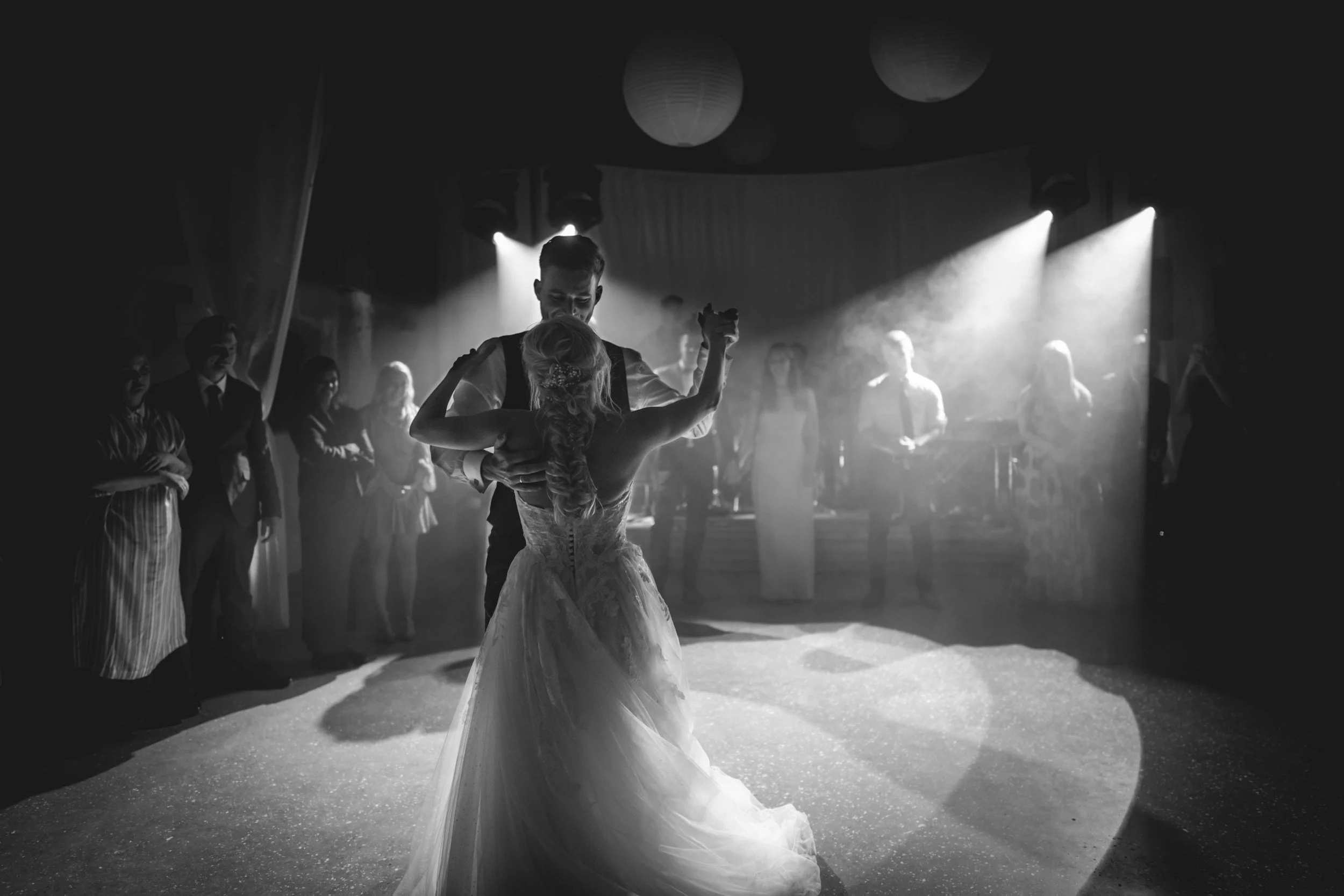 Wedding aisle with white chairs and floral arch